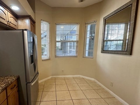 A kitchen with a refrigerator, cabinets, and a countertop.