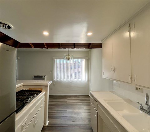 A kitchen with white cabinets and a black stove top.