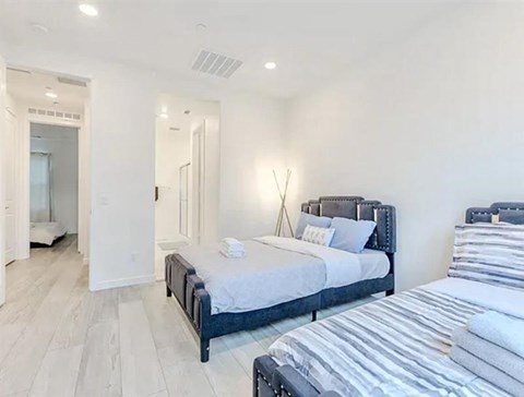 A bedroom with a large bed and a mirror on the wall.