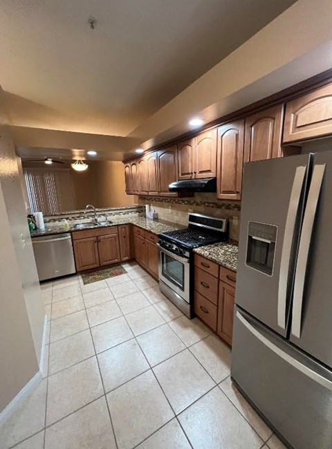 A kitchen with a refrigerator, stove, and microwave.