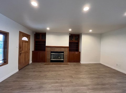 A room with a fireplace and wooden floors.
