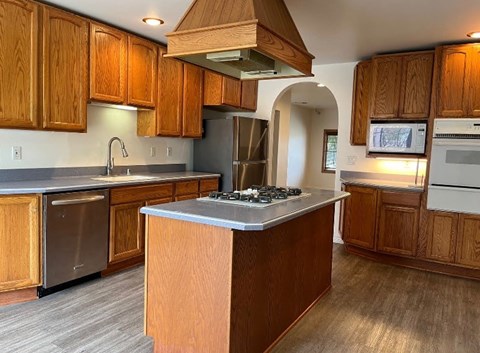 A kitchen with wooden cabinets and a central island.