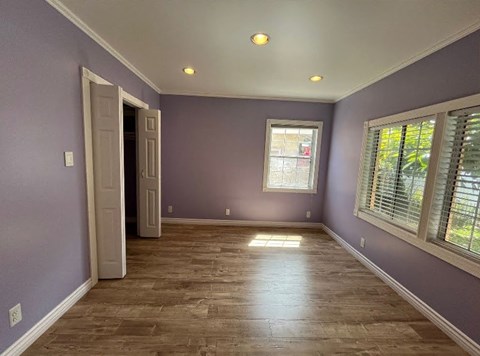A room with purple walls and wooden flooring.