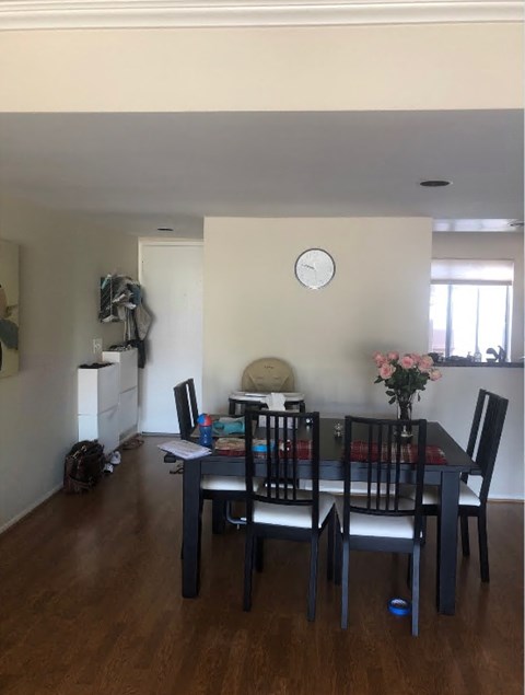 A dining room with a table set for four.