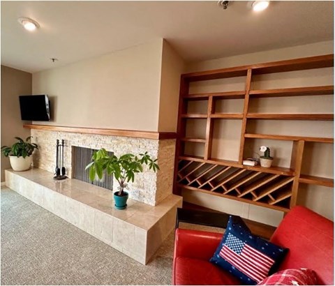 A living room with a red couch and a fireplace.