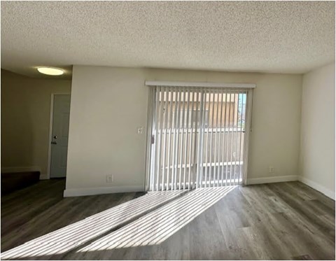 A room with a sliding door and wooden flooring.