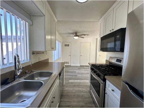 A kitchen with white cabinets and stainless steel appliances.