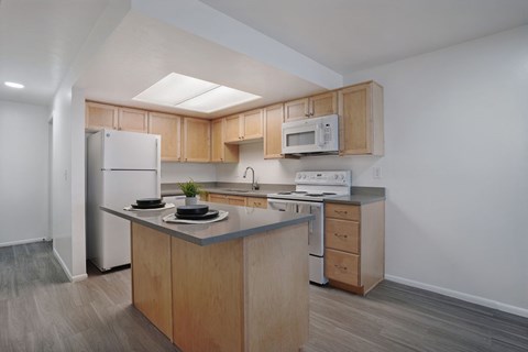 A kitchen with a refrigerator, microwave, and oven.