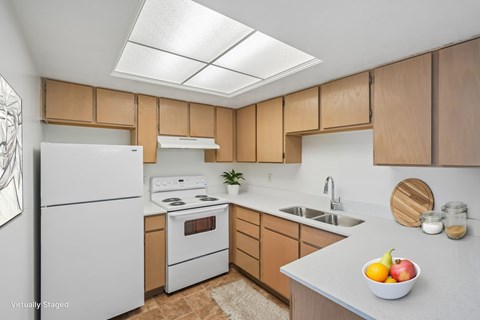 A kitchen with a white refrigerator and wooden cabinets.