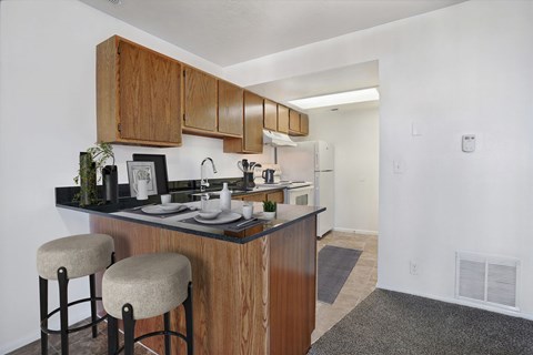 A kitchen with wooden cabinets and a black countertop.