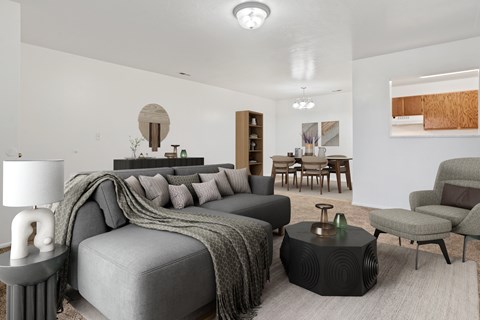 A modern living room with a grey sofa and a round table.