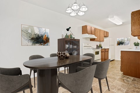 A modern dining room with a round table and grey chairs.