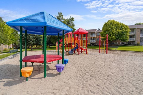 A playground with a blue canopy and red slide.