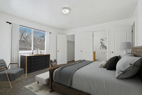 A bedroom with a bed, chair, and dresser.