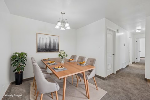 A dining room with a wooden table and grey chairs.