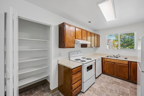A kitchen with white appliances and wooden cabinets.