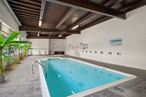 A large indoor swimming pool with a wooden ceiling.