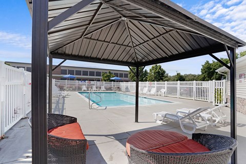 A patio with a pool and a canopy.