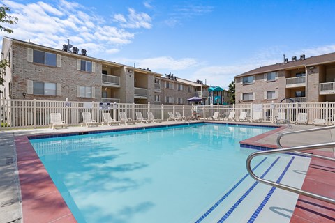 A swimming pool in front of apartment buildings.