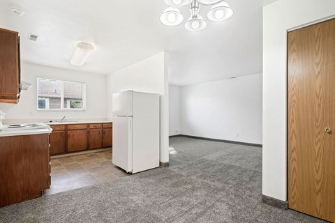 A kitchen with a white refrigerator and wooden cabinets.