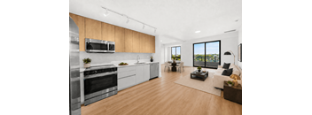 A modern kitchen with wooden floors and stainless steel appliances.