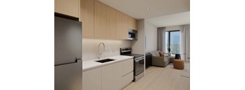 A modern kitchen with a refrigerator, sink, oven, and microwave.