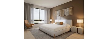 A bedroom with a large bed, a chair, and a window with curtains.