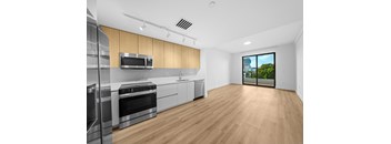 A kitchen with wooden floors and stainless steel appliances.