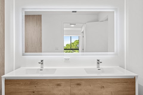 A bathroom with two sinks and a large mirror.