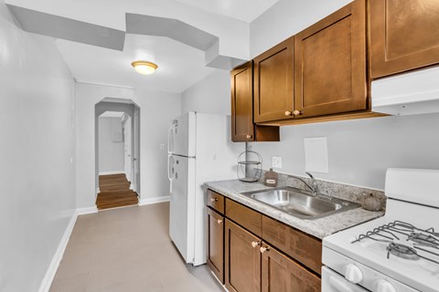A kitchen with white appliances and wooden cabinets.