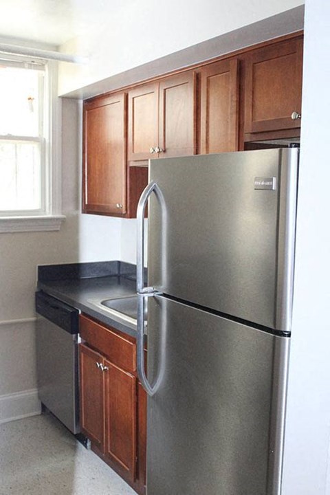 a kitchen with a stainless steel refrigerator and wooden cabinets