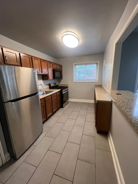 A kitchen with a refrigerator, microwave, and oven.