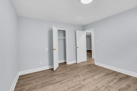 A room with two open doors and a light on the ceiling.