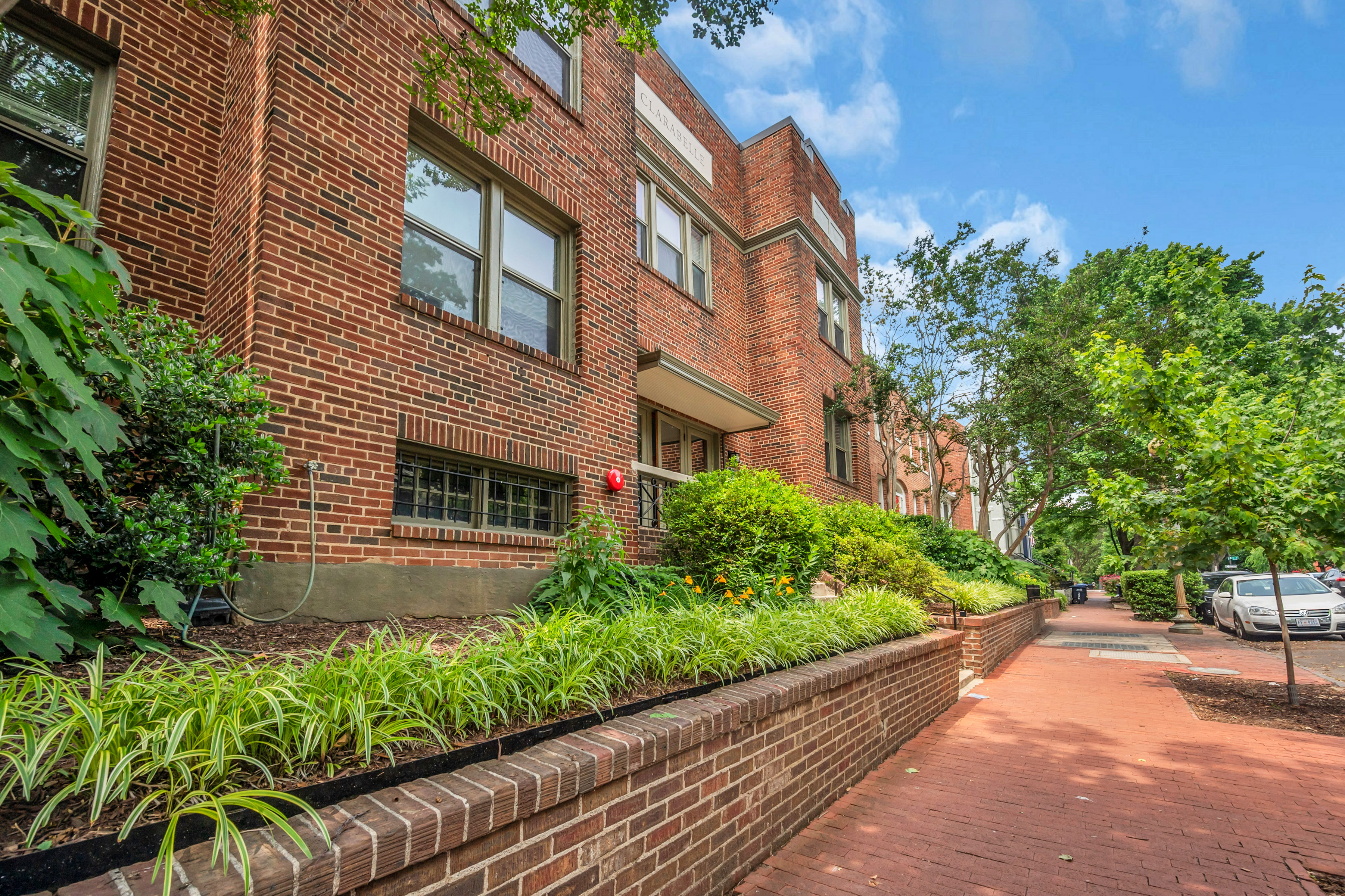 A red brick building with a green lawn in front.