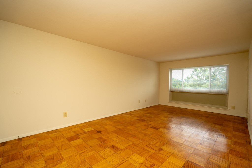 a empty room with wooden floors and a window