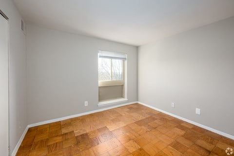 A room with wooden flooring and a window.