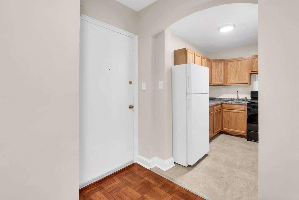a kitchen with a white refrigerator and wooden cabinets