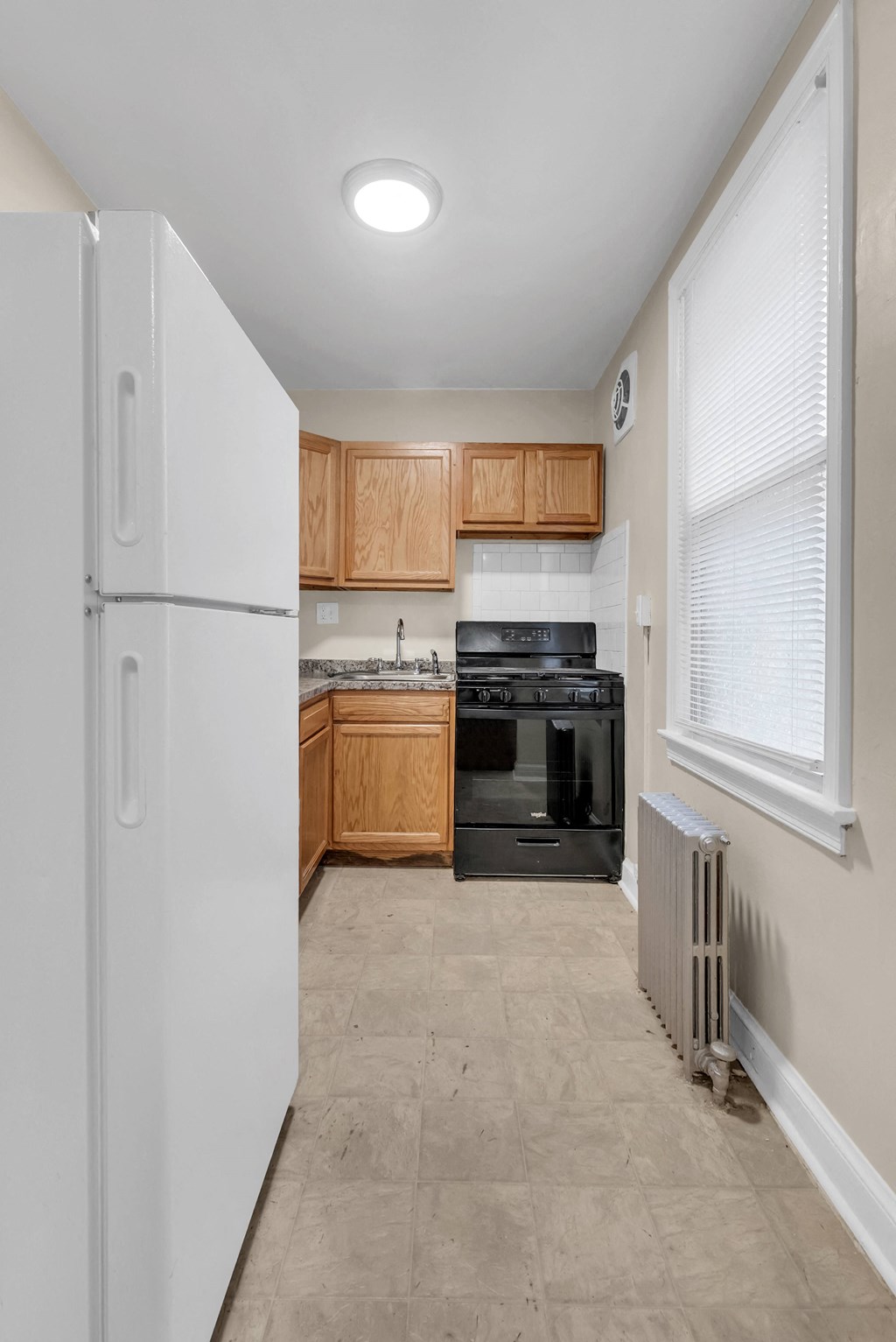 a kitchen with black appliances and wooden cabinets and a white refrigerator