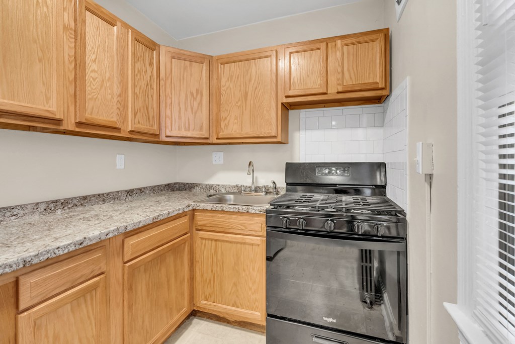 an empty kitchen with wood cabinets and stainless steel appliances