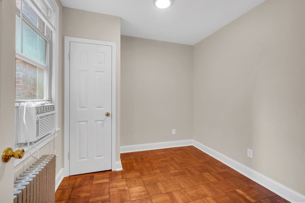 an empty living room with wood floors and a white door