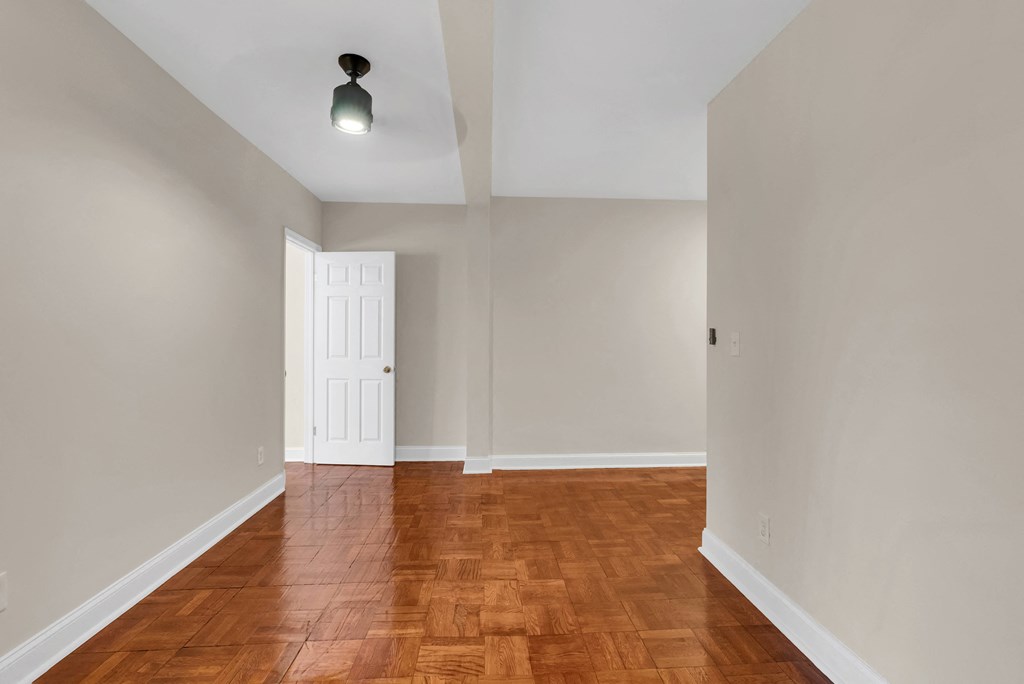 a empty living room with wood floors and a white door
