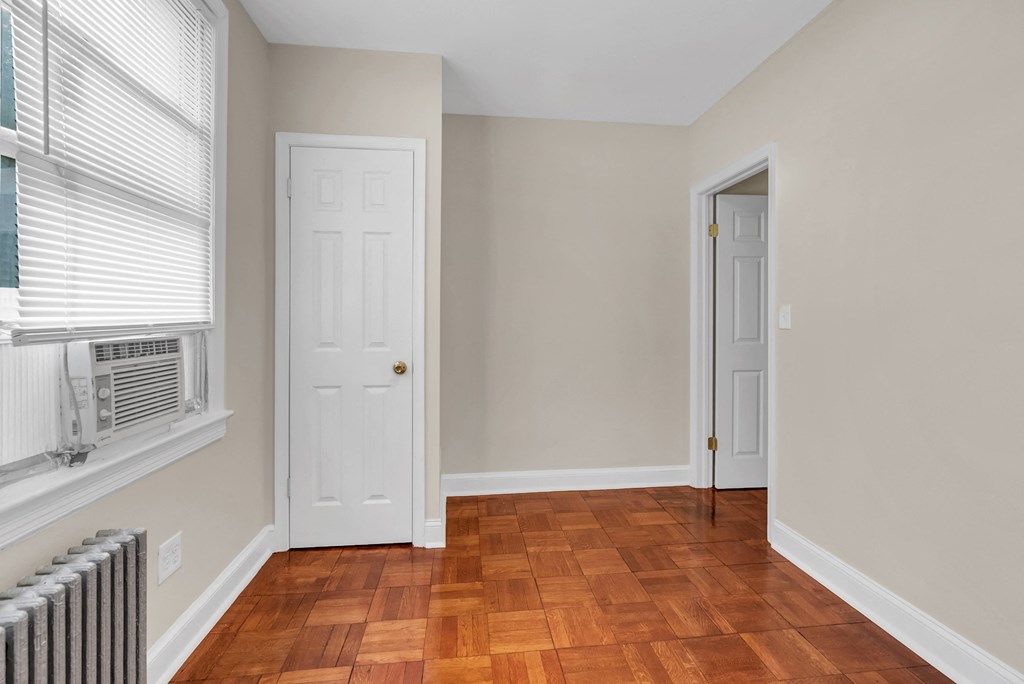 a living room with wood floors and a white door and a window