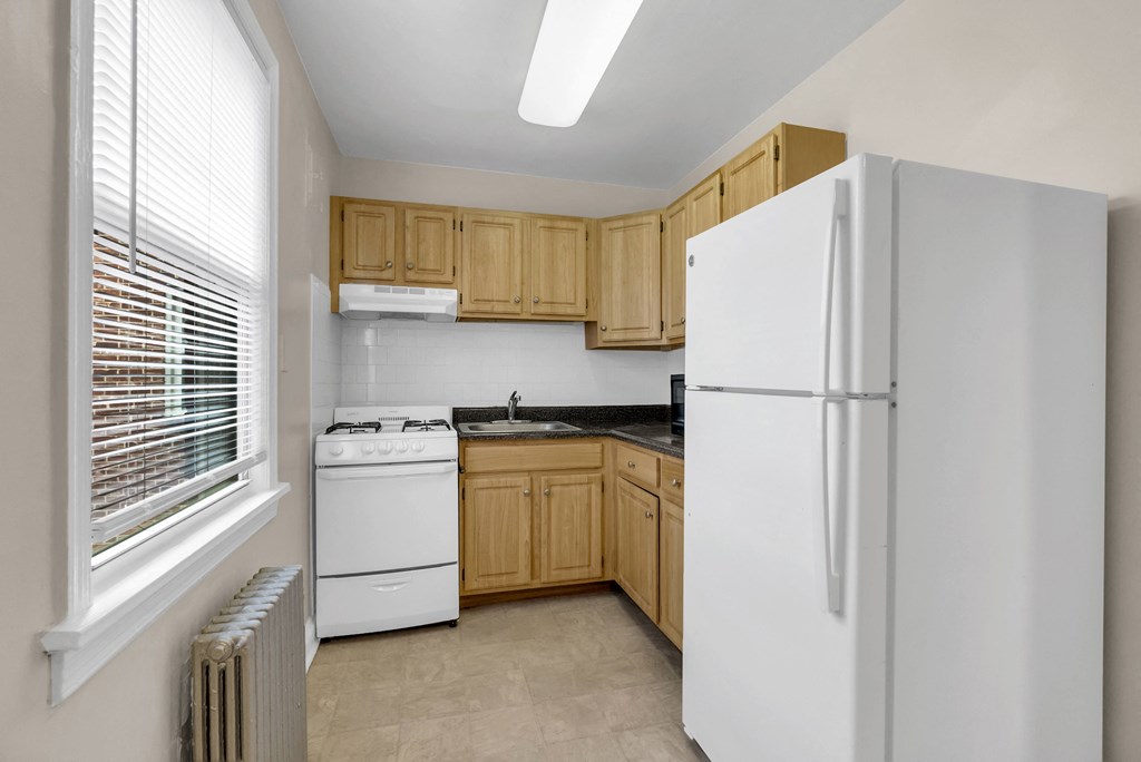a kitchen with white appliances and wooden cabinets