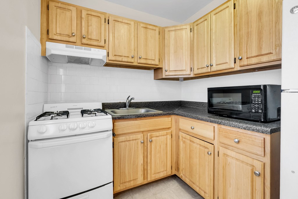a kitchen with white appliances and wooden cabinets