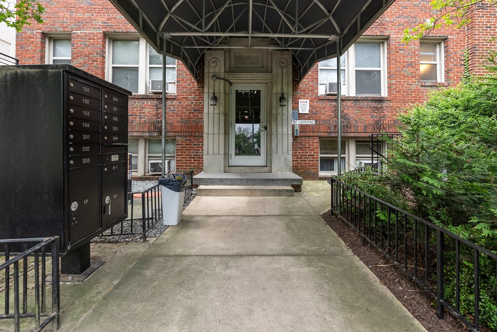 the front of a building with a concrete walkway and a door