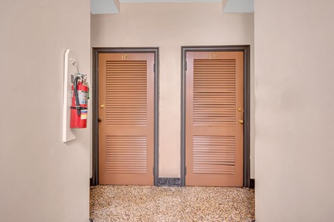 two doors with wooden shutters next to each other next to a fire hydrant