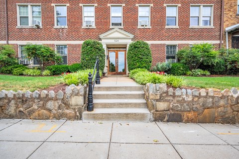 the front door of a brick building with stairs in front of it