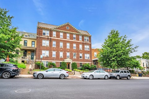 a large brick building with cars parked in front of it