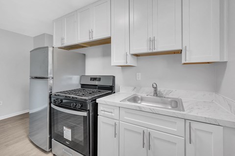 A kitchen with white cabinets and a stainless steel dishwasher.