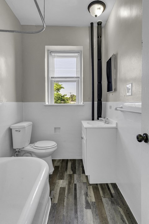 a bathroom with a toilet sink and tub and a window